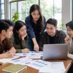 Mahasiswa menganalisis grafik dan memeriksa informasi digital bersama di ruang belajar kampus